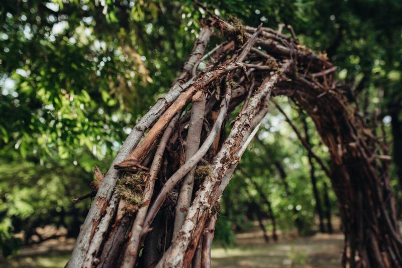 A closeup of an archway made of intertwined twigs.