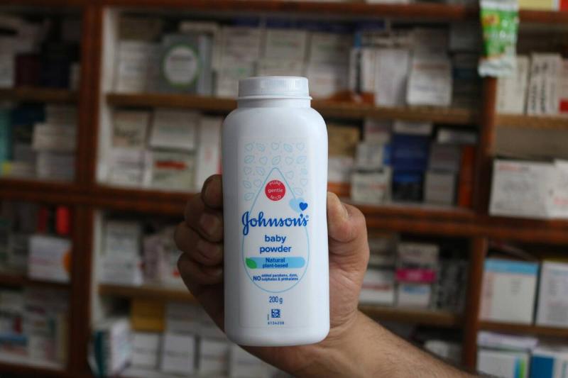 A man is holding a bottle of Johnson and Johnson Baby Powder at a  drugstore in Srinagar, India, on June 13, 2024.