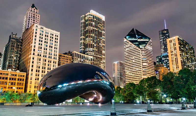 'The bean' and the surrounding buildings at night, all lit up.