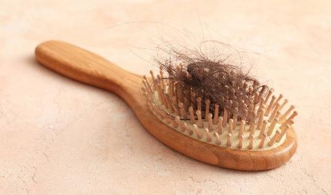 A hairbrush with a clump of hair in it.