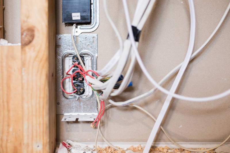 A closeup of an electrical outlet with the wiring visible.