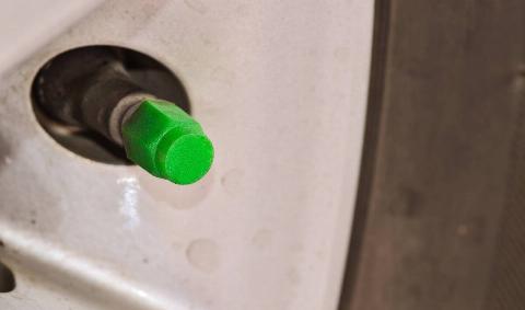 A green valve cap on a tire.