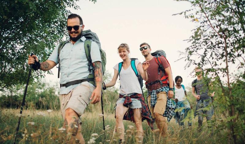 A group of friends hiking through some tall grass.