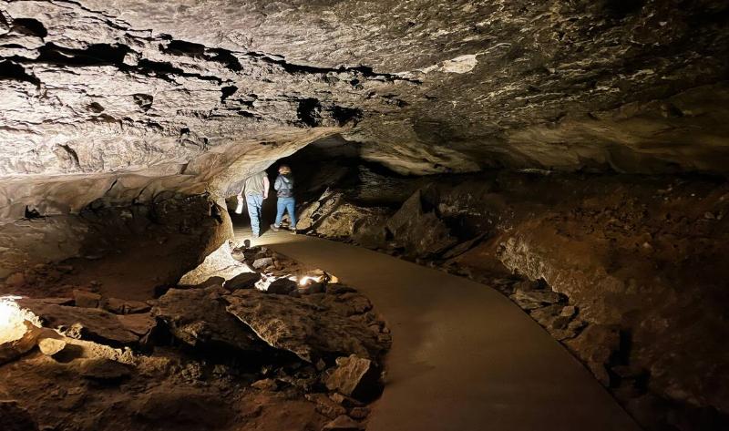Two people walking deeper into Mammoth Caves.