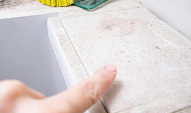A person pointing at a dusty surface.
