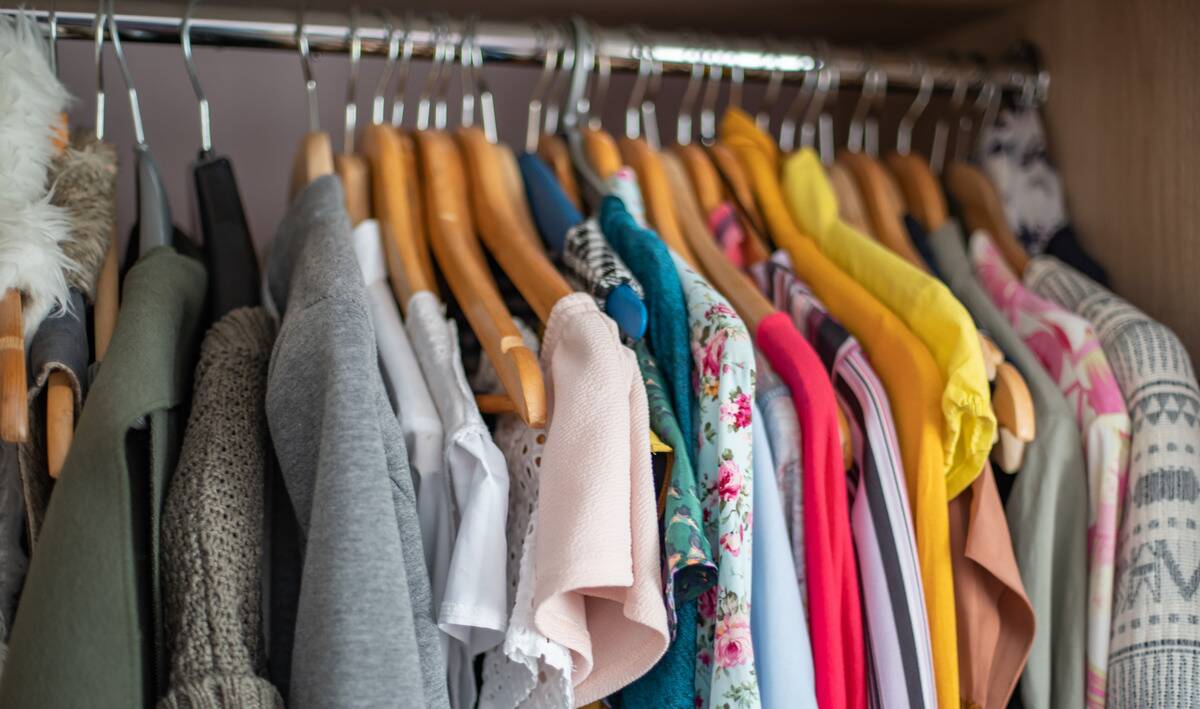 A closet rack of shirts hung up on hangers.