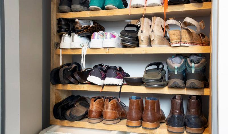 A shoe rack with many pairs of shoes.