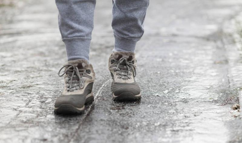 A person walking on an icy sidewalk.