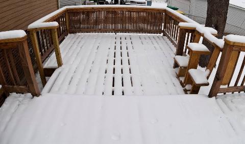 A wooden deck covered in snow.