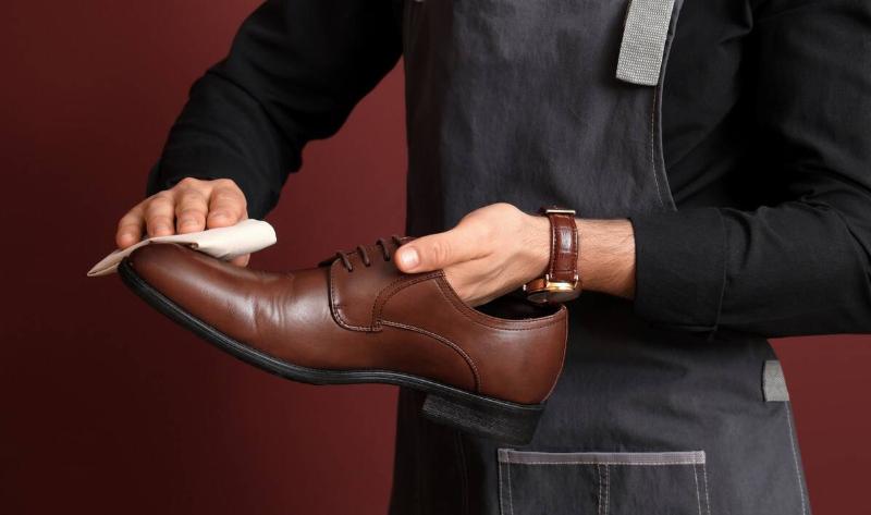 A person polishing a leather shoe.