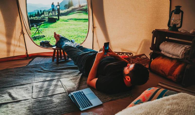 A man laying inside a tent with a rug.