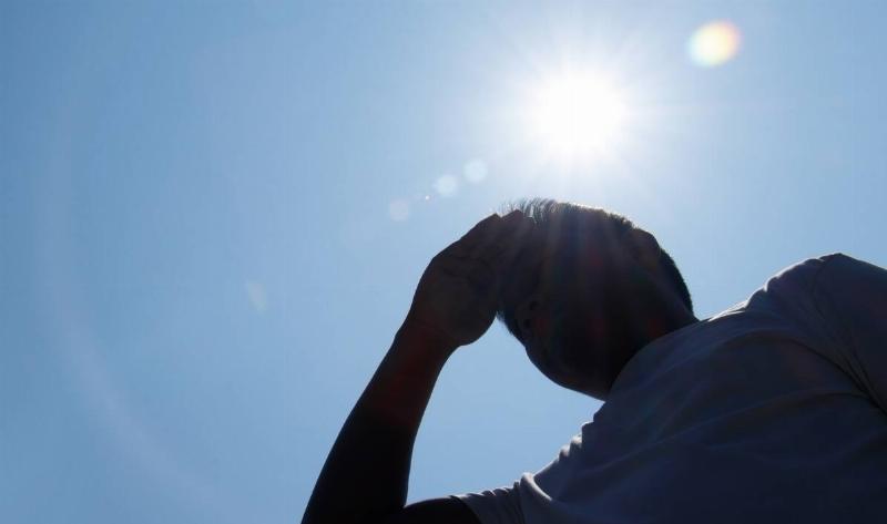 A man standing under the blazing sun.