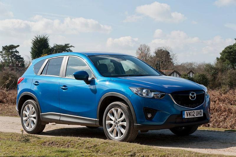 Blue 2013 Mazda CX-5 parked in the middle of a dirt road