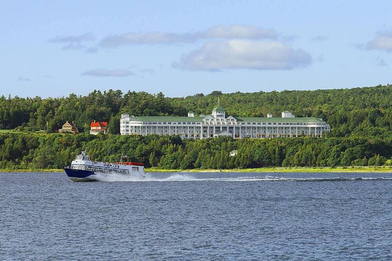 A tour boat speeds past the Grand Hotel