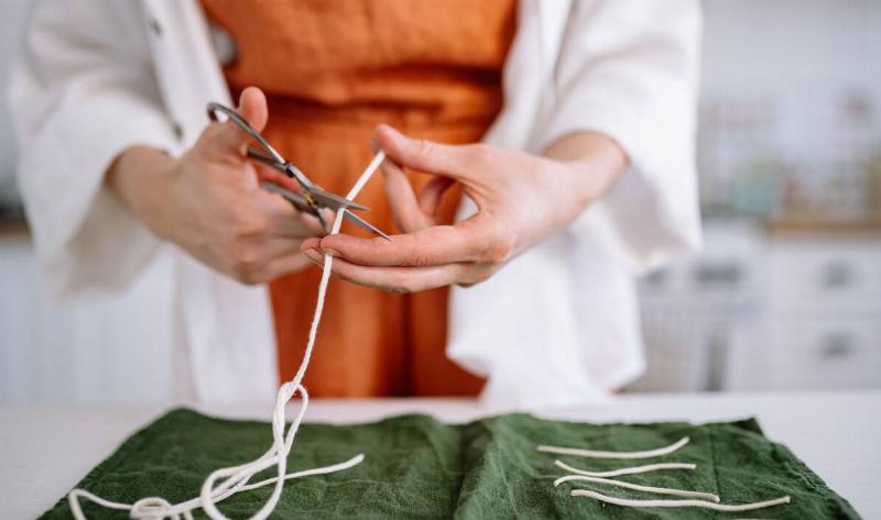 A person cutting short lengths of string.