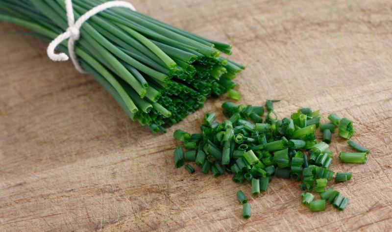 Chopped chives on a cutting board.