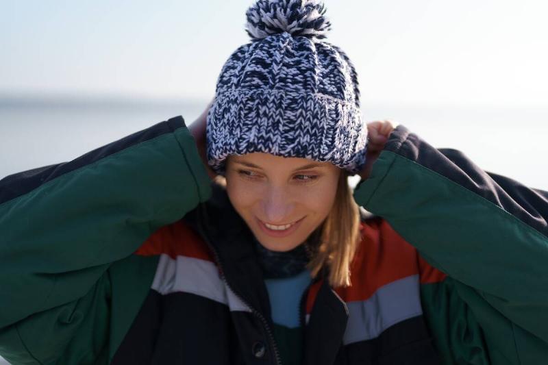 Authentic winter woman portrait arranging her hat