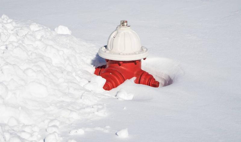A fire hydrant buried in snow.