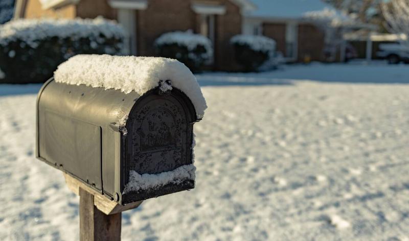 A mailbox with snow on top of it.
