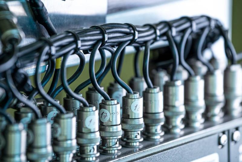 Close-up side view of a wire and a numbered plugs connected to each  other in the manufacture of military equipment. The concept of a complex
 defense