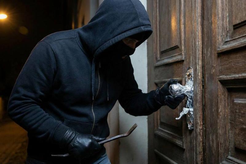 Man trying to open door with aluminum foil on it. 