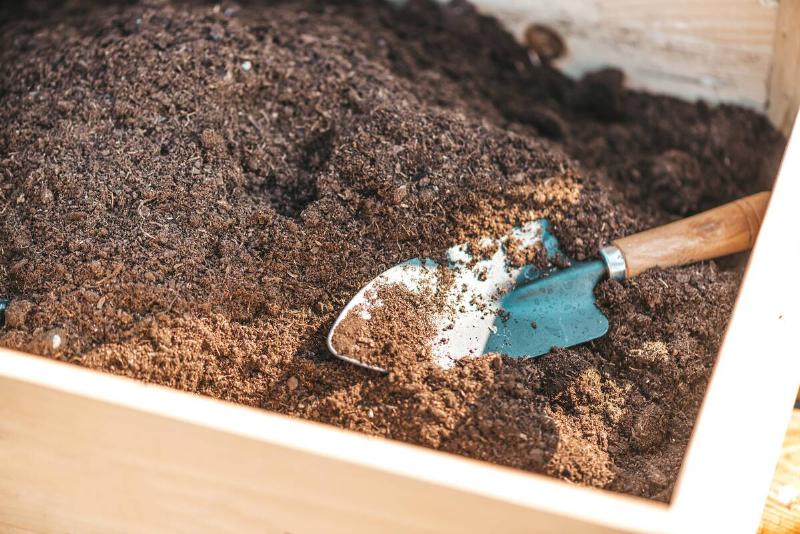 Keep calm and Garden on. Close up of wooden box with soil and garden spade, shovel prepared for planting vegetables or flowers. Horizontal shot. Selective focus