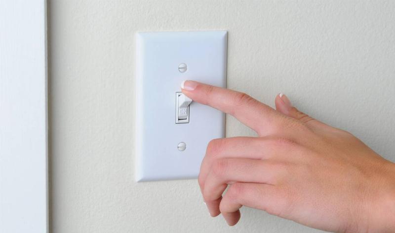 A person flicking a light switch.