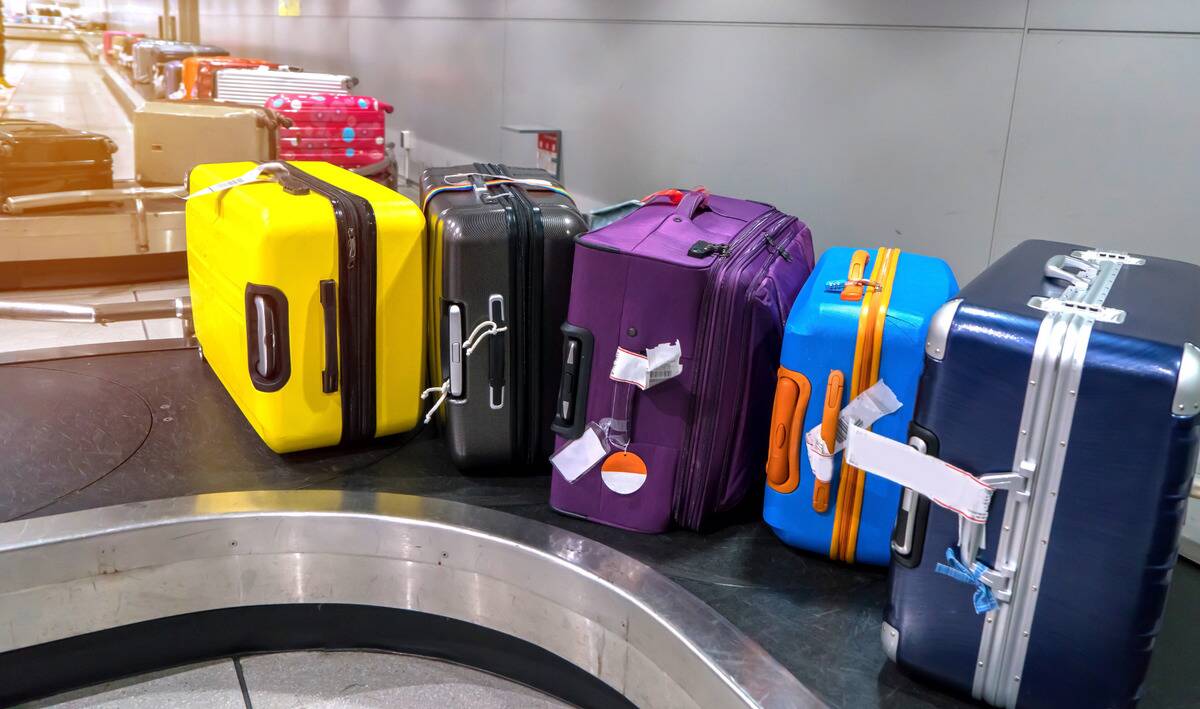 A row of suitcases on an airport conveyor.