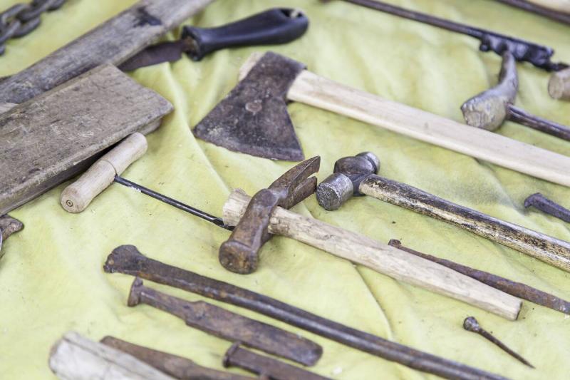 a collection of old rusted tools laid out.