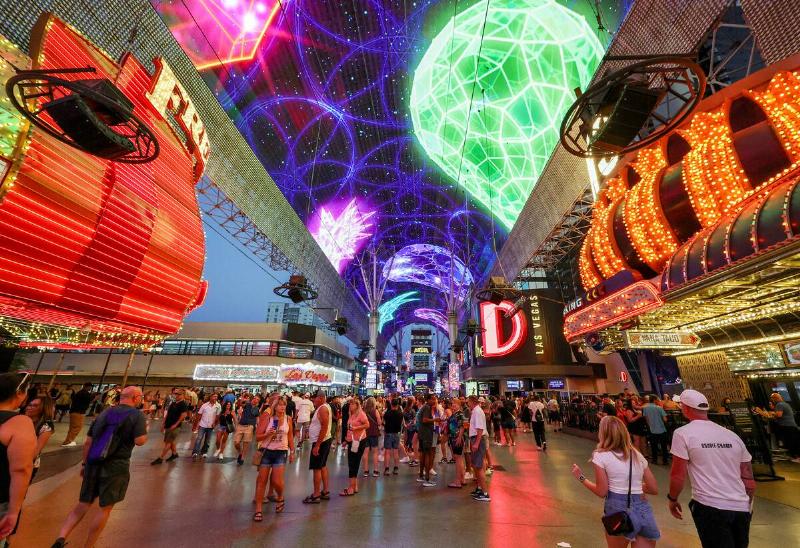 People walk under the Fremont Street Experience attraction's Viva Vision canopy screen on August 30, 2025 in downtown Las Vegas, Nevada.