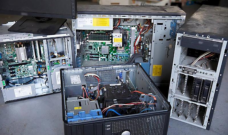 A few open electronics, mostly PC towers, on a table.