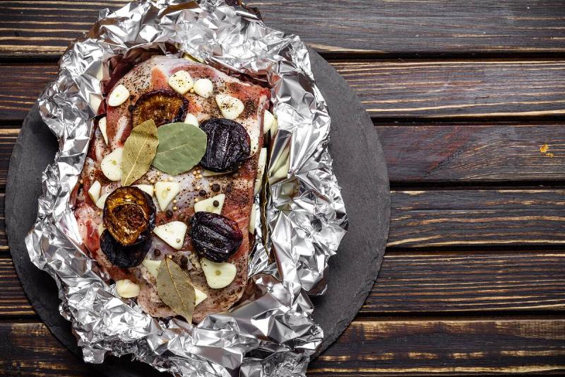 Raw pork in aluminum foil. 