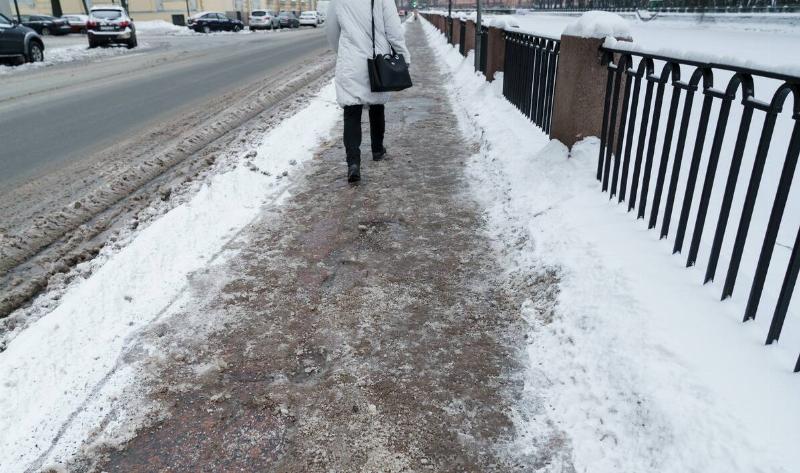 A person walking along a slushy city street.