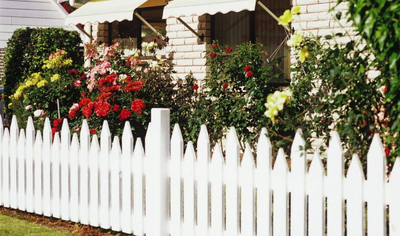 A garden with a white picket fence.