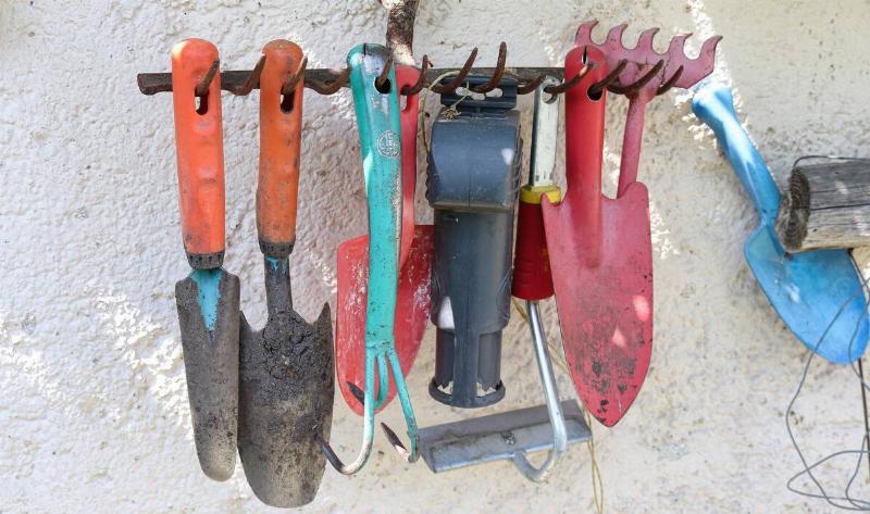 A rack of hanging garden tools.