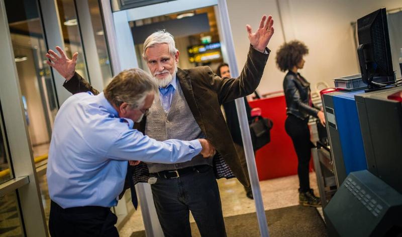 A man being scanned by a TSA agent.