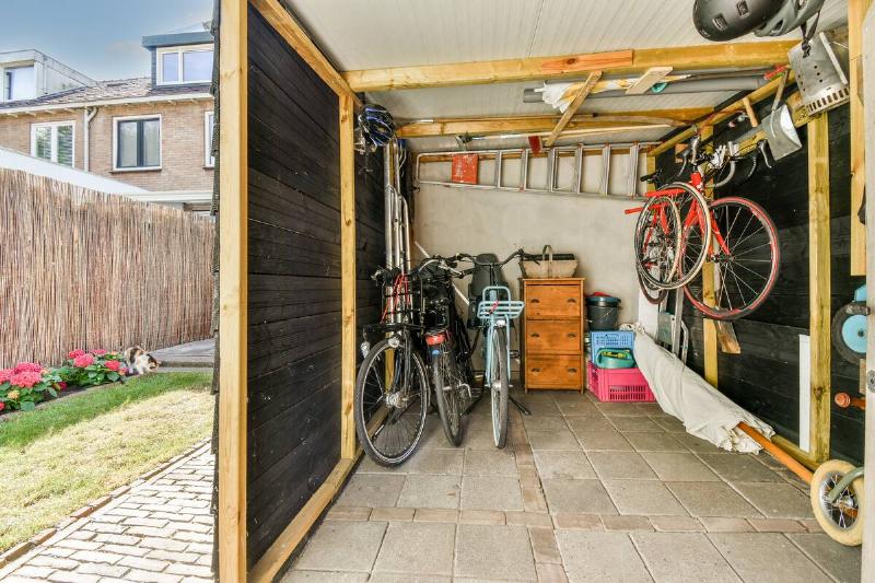 Spacious garage with bicycles and storage furniture near small garden