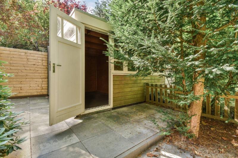 Simple small patio with small garden near wooden fence