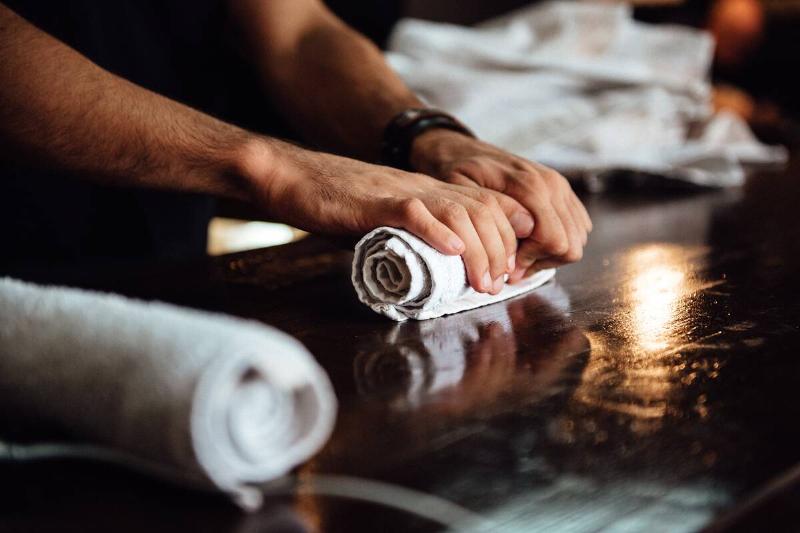Rolling up cloths on a table. 