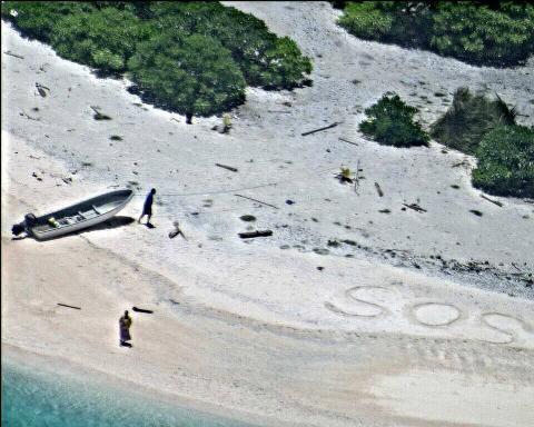 A pair of stranded mariners signal for help by writing 