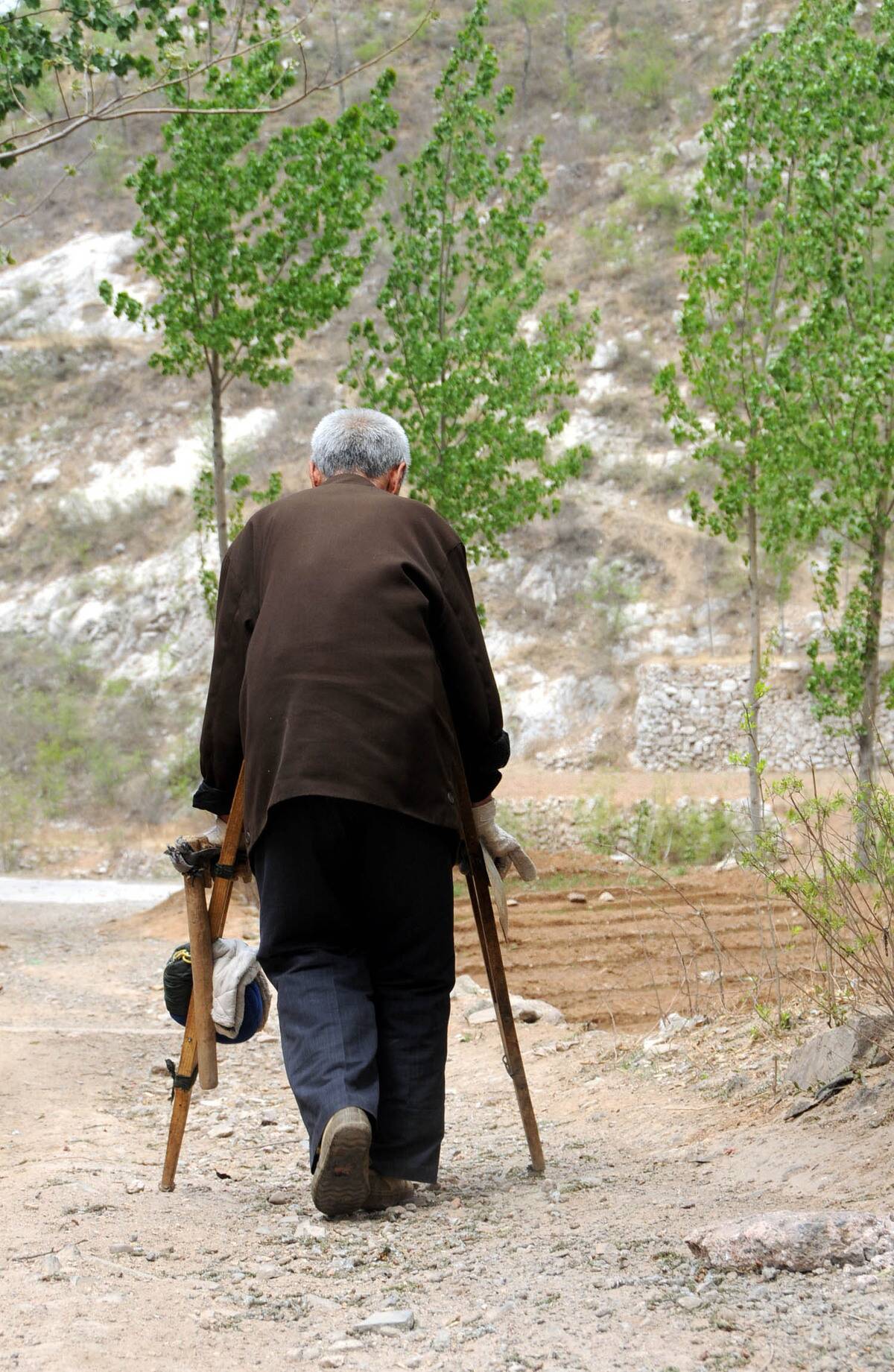 Ma Sanxiao walking on the path to the mountains in a village of Jingxing County in north China's Hebei Province.