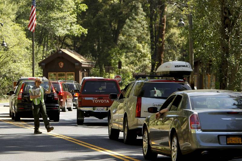 A park ranger greets visitors entering the arch rock, west gate entrance into Yosemite National Park.