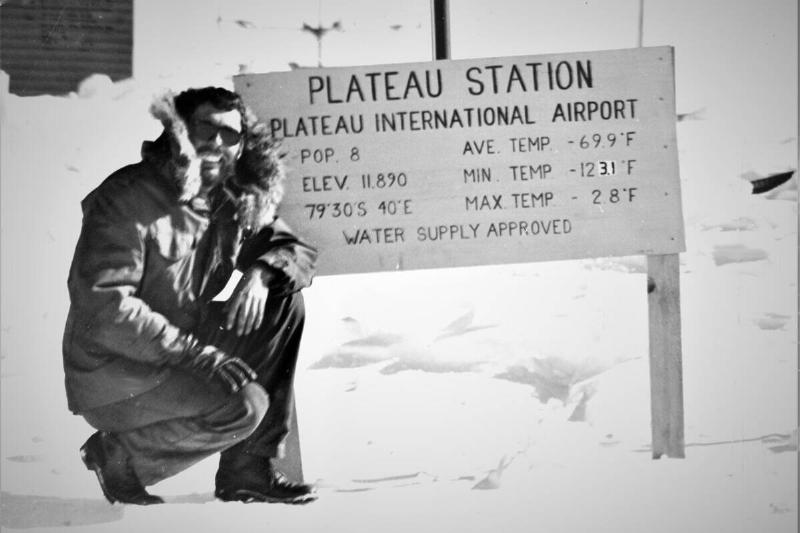 A man standing in front of a sign at Plateau Station.
