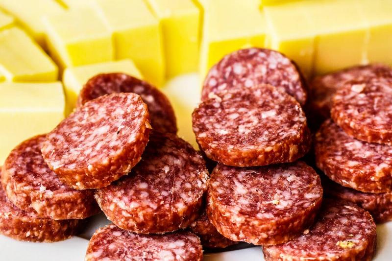 Slices of dried sausage and pieces of cheese. 