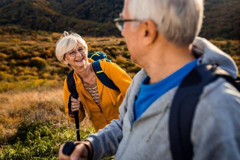 A senior man and woman hiking together. 