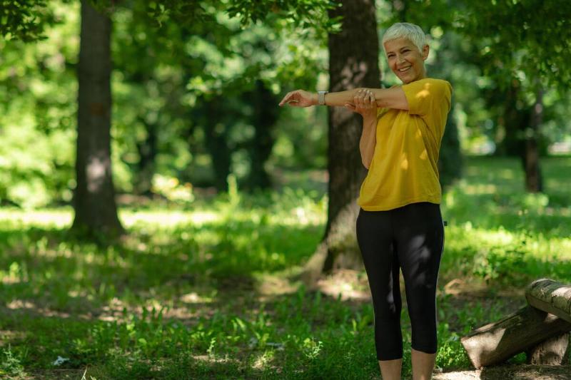 Senior woman stretching outside. 