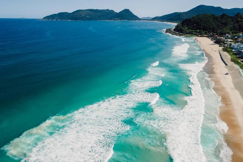 Beach and ocean with surfing waves in Brazil.