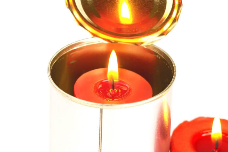 A red candle inside of a tin can. 