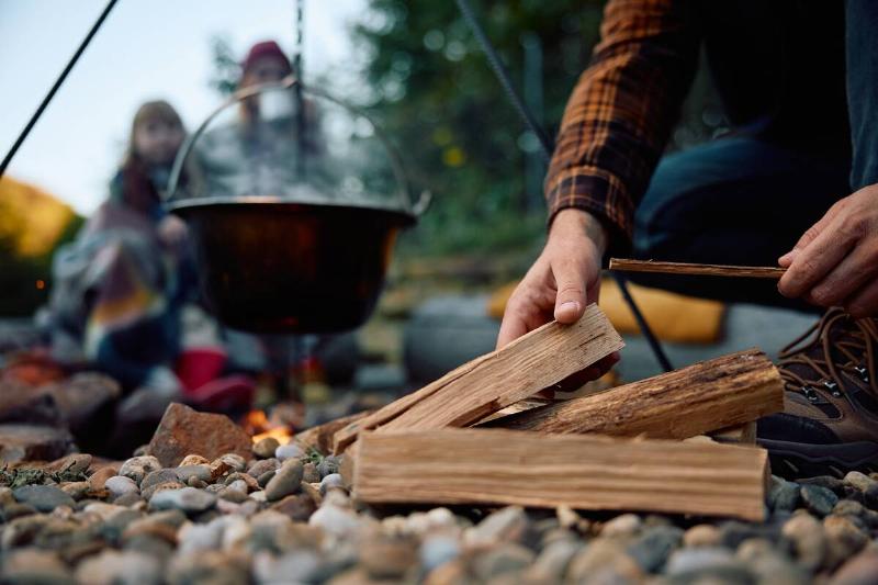 Close up of man collecting log wood during family camping.