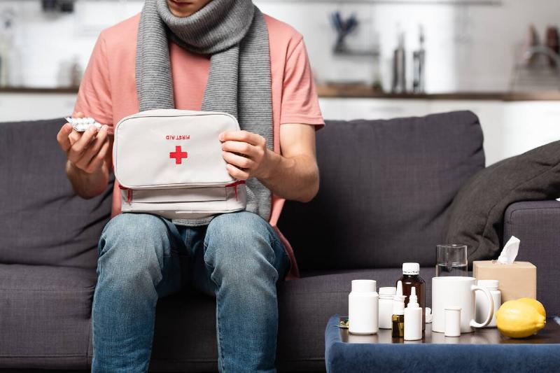 A sick person packing a first-aid kit. 